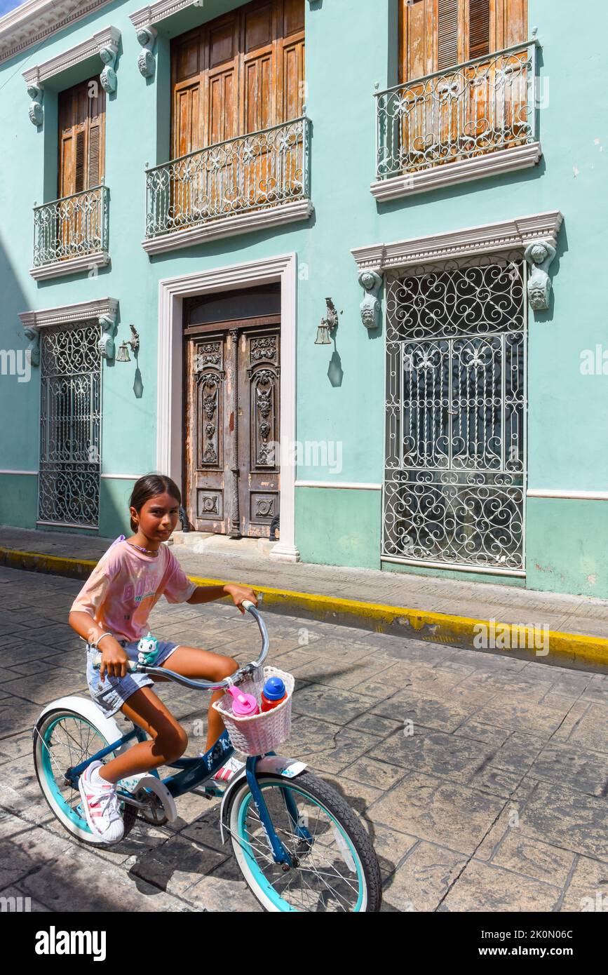 Child riding a bicycle in downtown Merida, Yucatan, Mexico Stock Photo