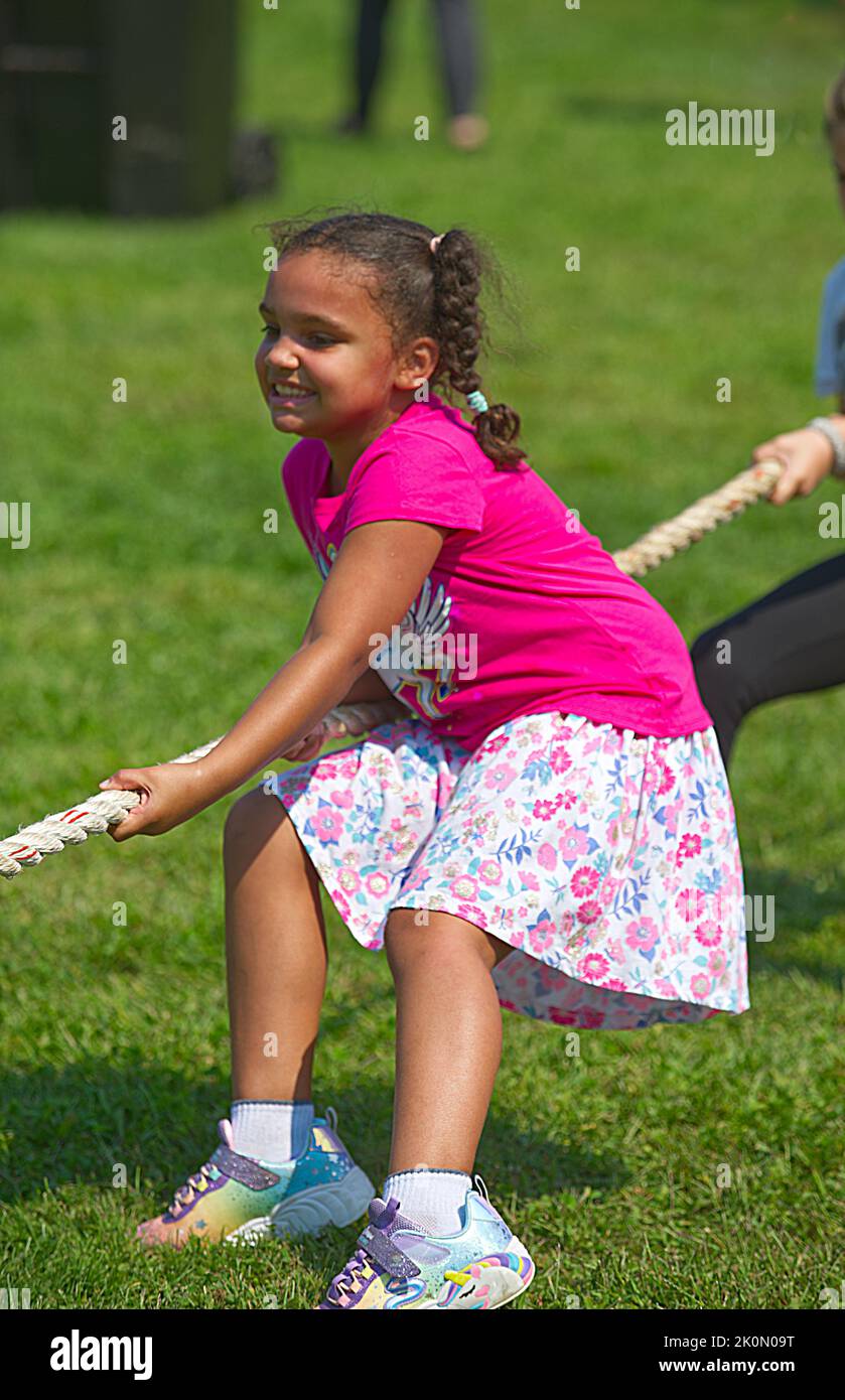 A young girl engaged in a tug of war at the Eastham Windmill Weekend fair on Cape Cod, USA Stock Photo