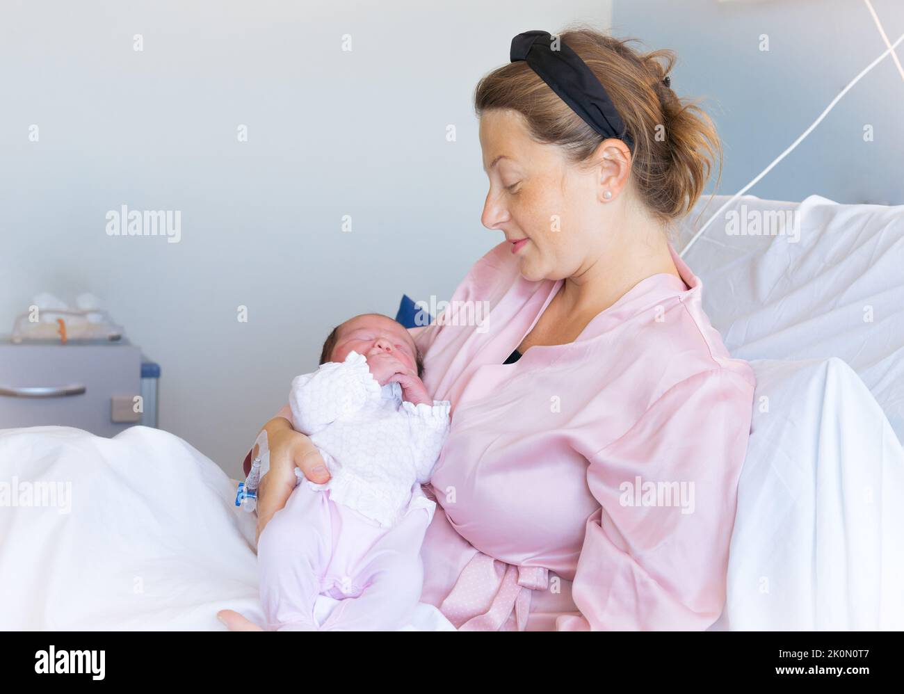 New born baby - girl with remainder of umbilical cord after successful  childbirth. Real birthing and new