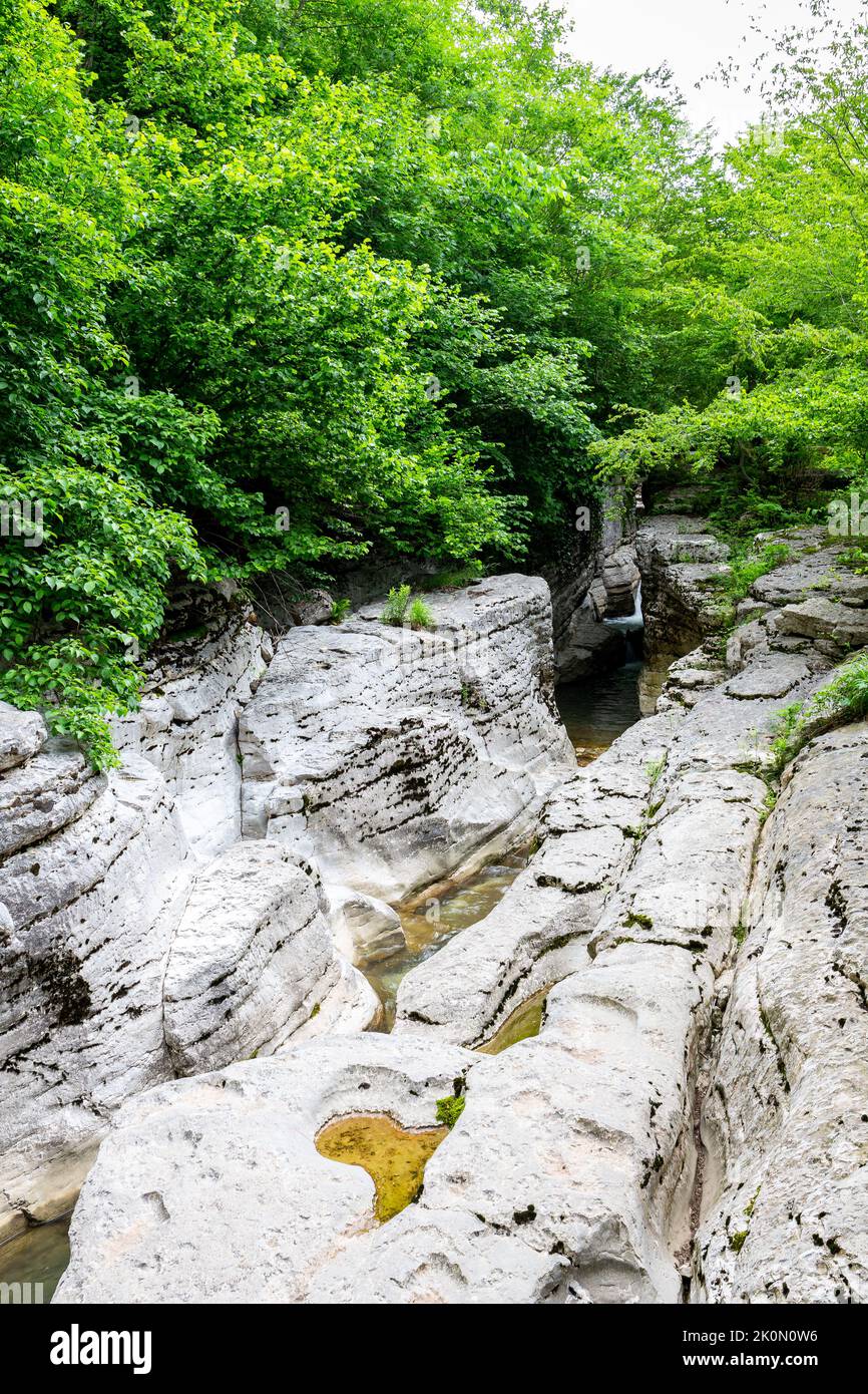 Massive chalk stones riverbed with wild river and pools formed by Okatse Waterfall in gorge of Satsikvilo, lush vegetation, Georgia. Stock Photo