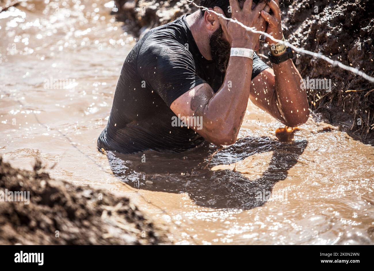 Merida, Spain - Sept 11th, 2022: FarinatoRace Merida 2022. Toughest obstacle course in the world. Trench flooded with barbed wire Stock Photo