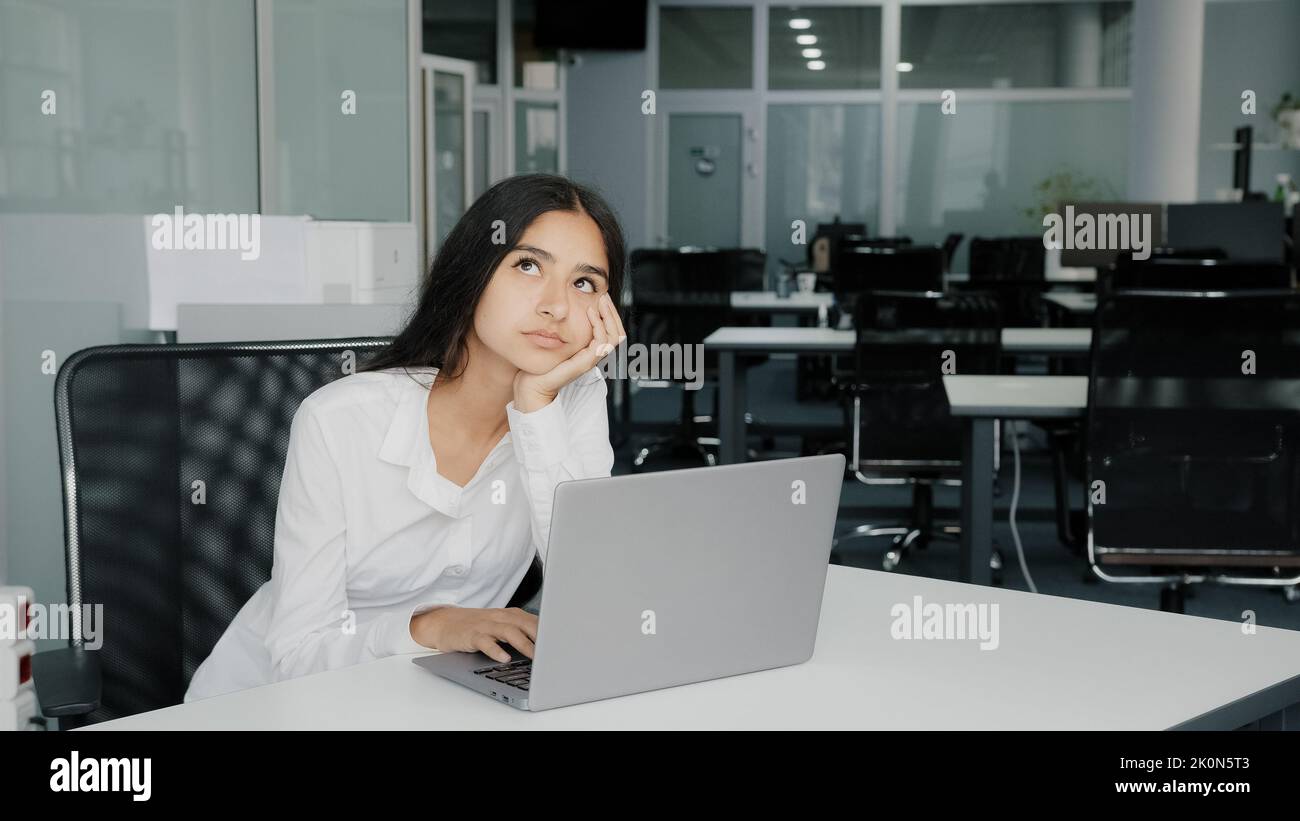 Bored lazy arabian businesswoman upset female clerk sits at office has problem stress. African active colleague man cheering up passive friend ask to Stock Photo