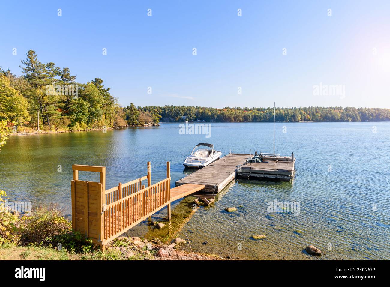 Wooden jetty and floating pontoon on the bank of a mighty river on a sunny autumn day Stock Photo