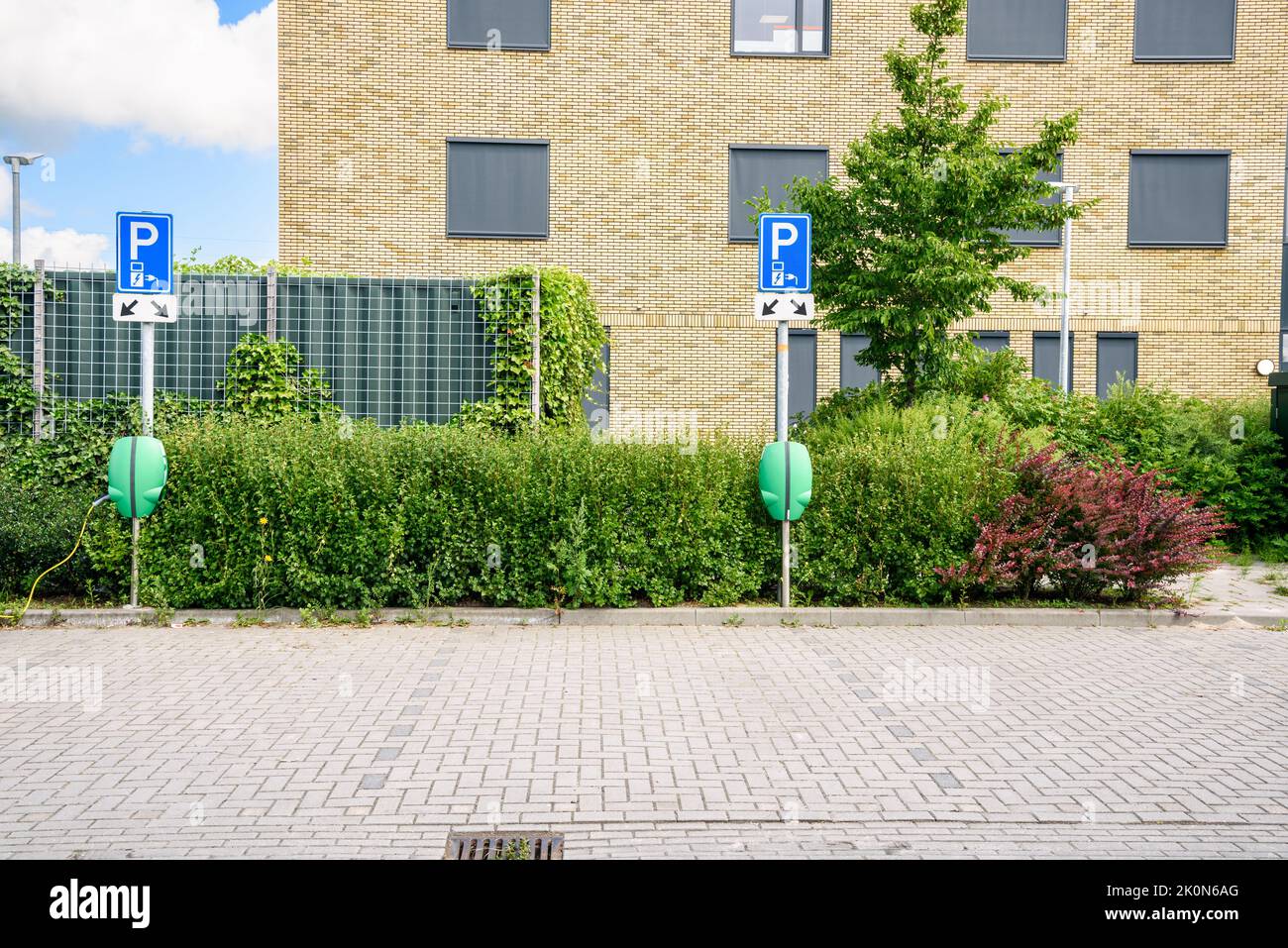 Deserted charging station for electric cars in a car park. An office building is in background. Stock Photo