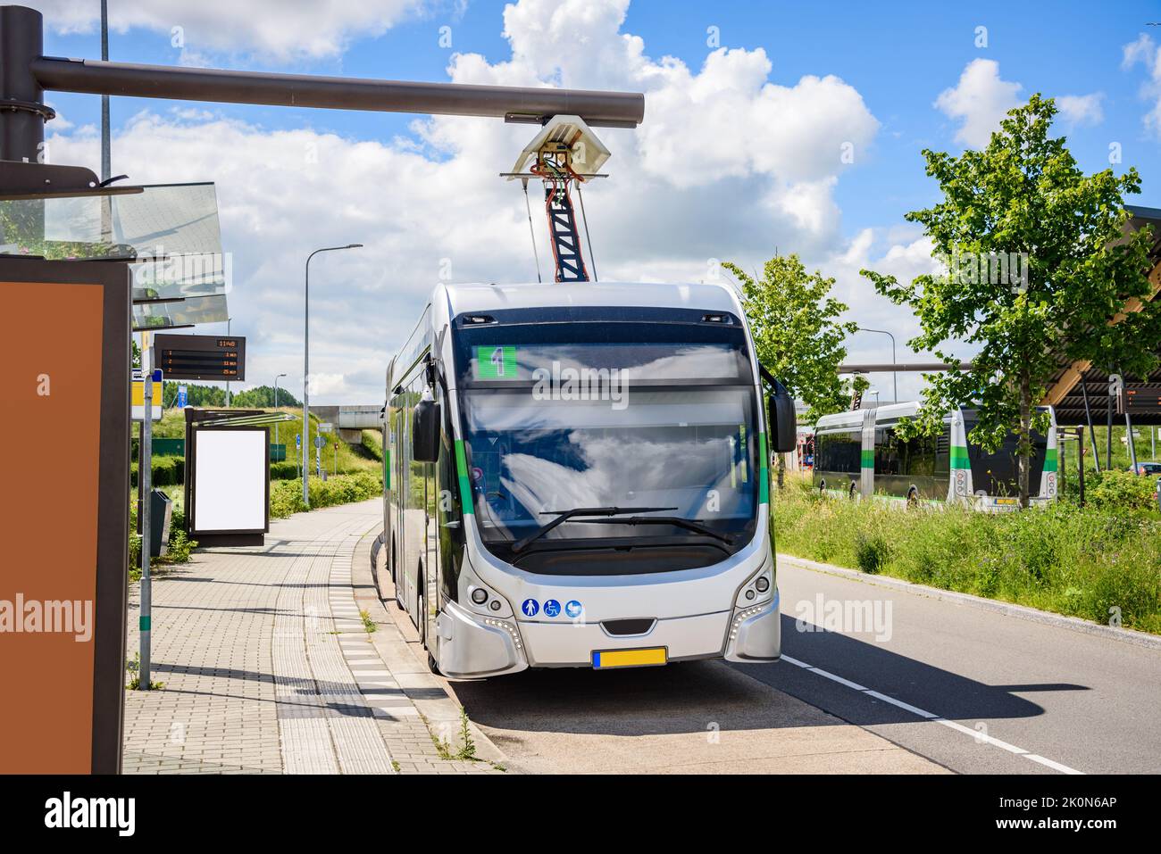 Electric bus being recharged at bus station on a sunny summer day Stock Photo