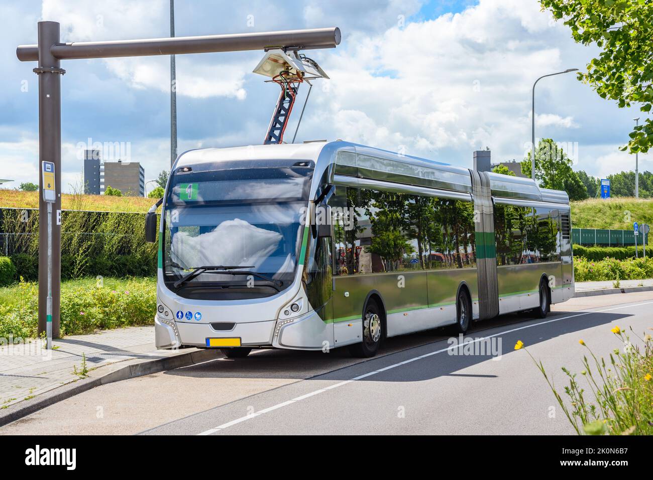 Electric city bus at a charging station on a sunny summer day Stock Photo