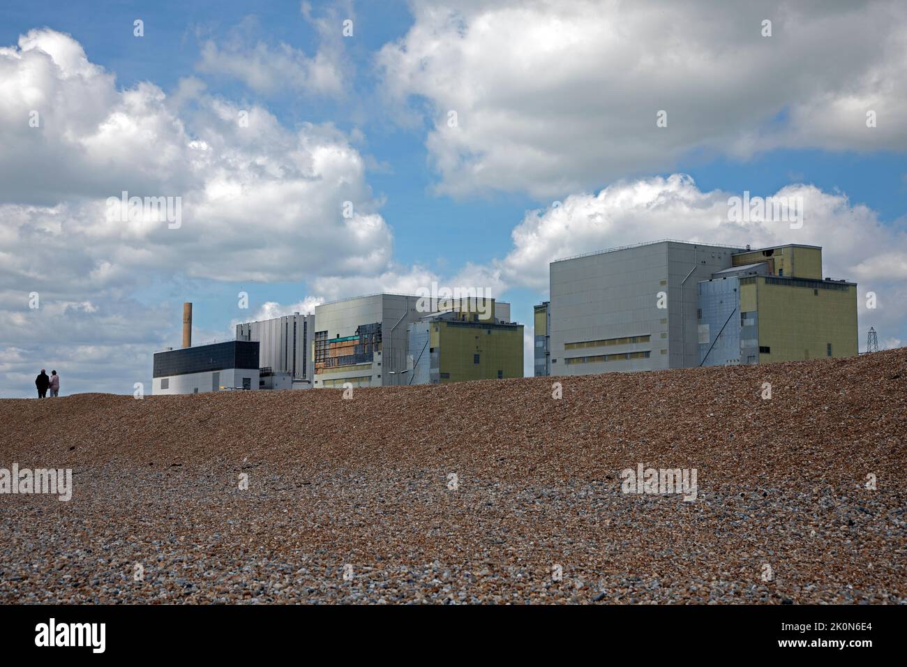 Two people walking past Dungeness Nuclear Power Station, Kent, England. Stock Photo