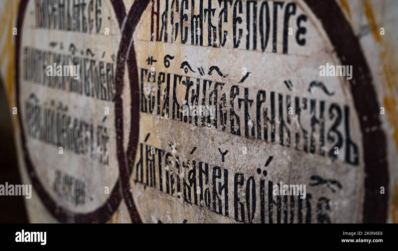 Fragment of the Cyrillic Old Slavic letter on the wall in the temple. Selected focus. High quality photo Stock Photo