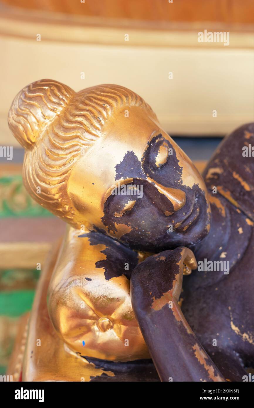 A gold sleeping Buddha statue that is tarnished and worn away in places, at Watt Munisotaram Cambodian Buddhist Monastery in Hampton, Minnesota. Stock Photo