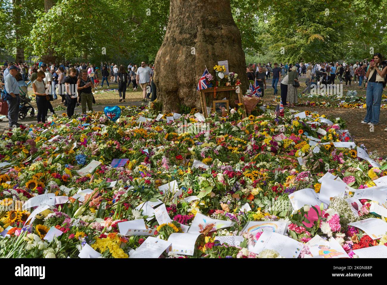 Crowds gathered around a floral tribute to the Queen, at the base of a tree in Green Park, London UK, on 12th September 2022 Stock Photo