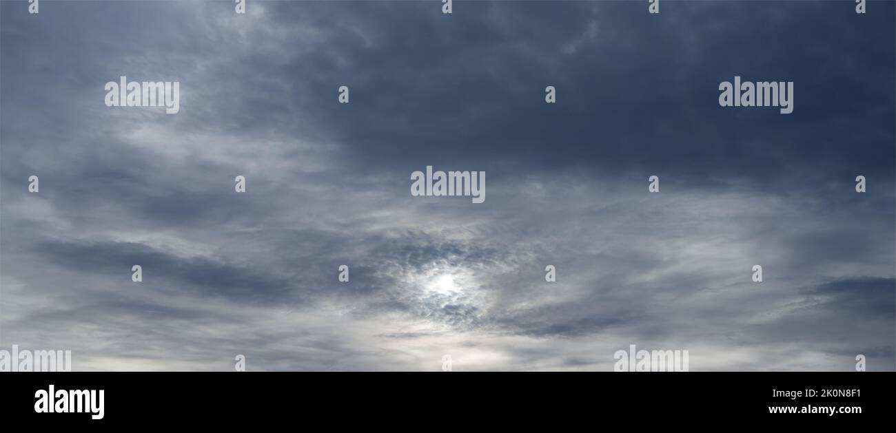 Panorama of sky with sun through stormy clouds Stock Photo