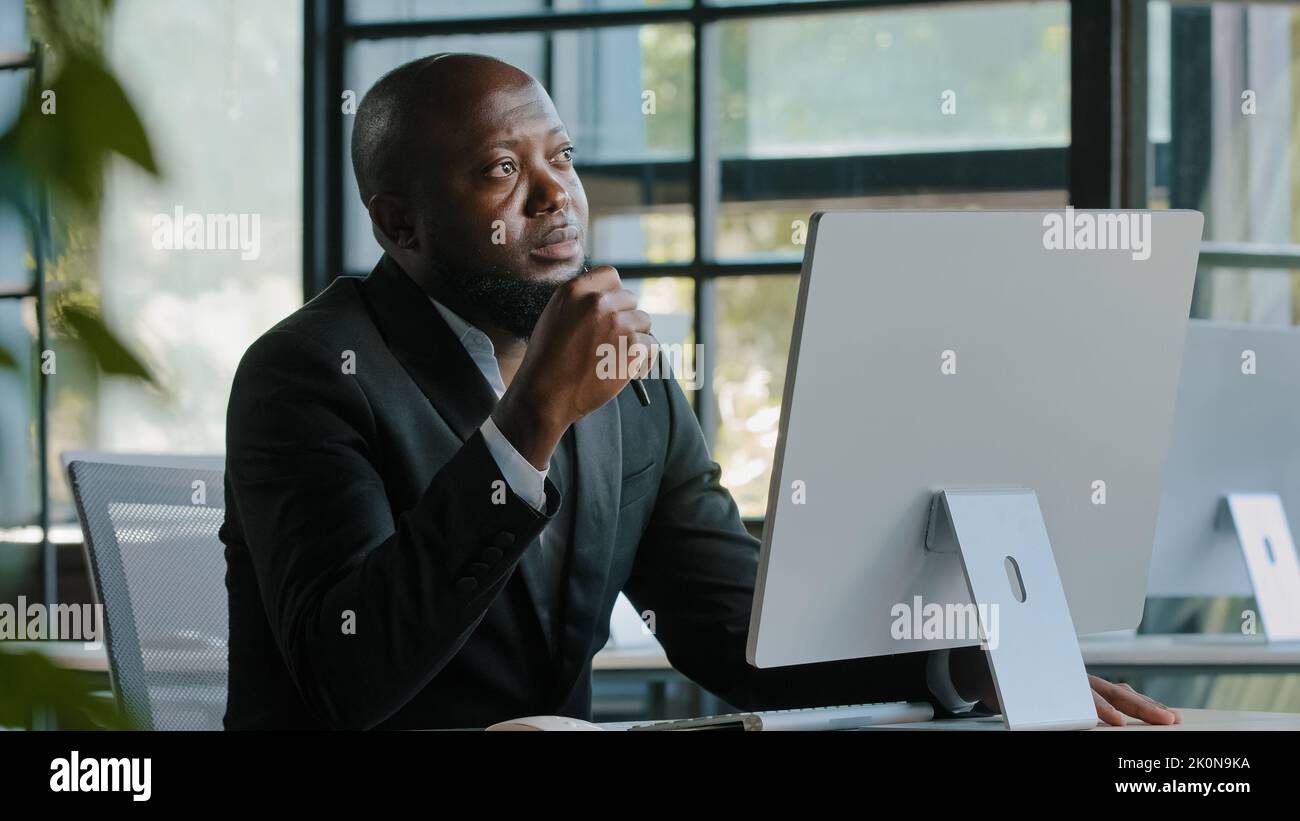 Thoughtful dreamy african man executive worker teacher male team leader has dilemma question thinking decision brainstorming create startup project Stock Photo