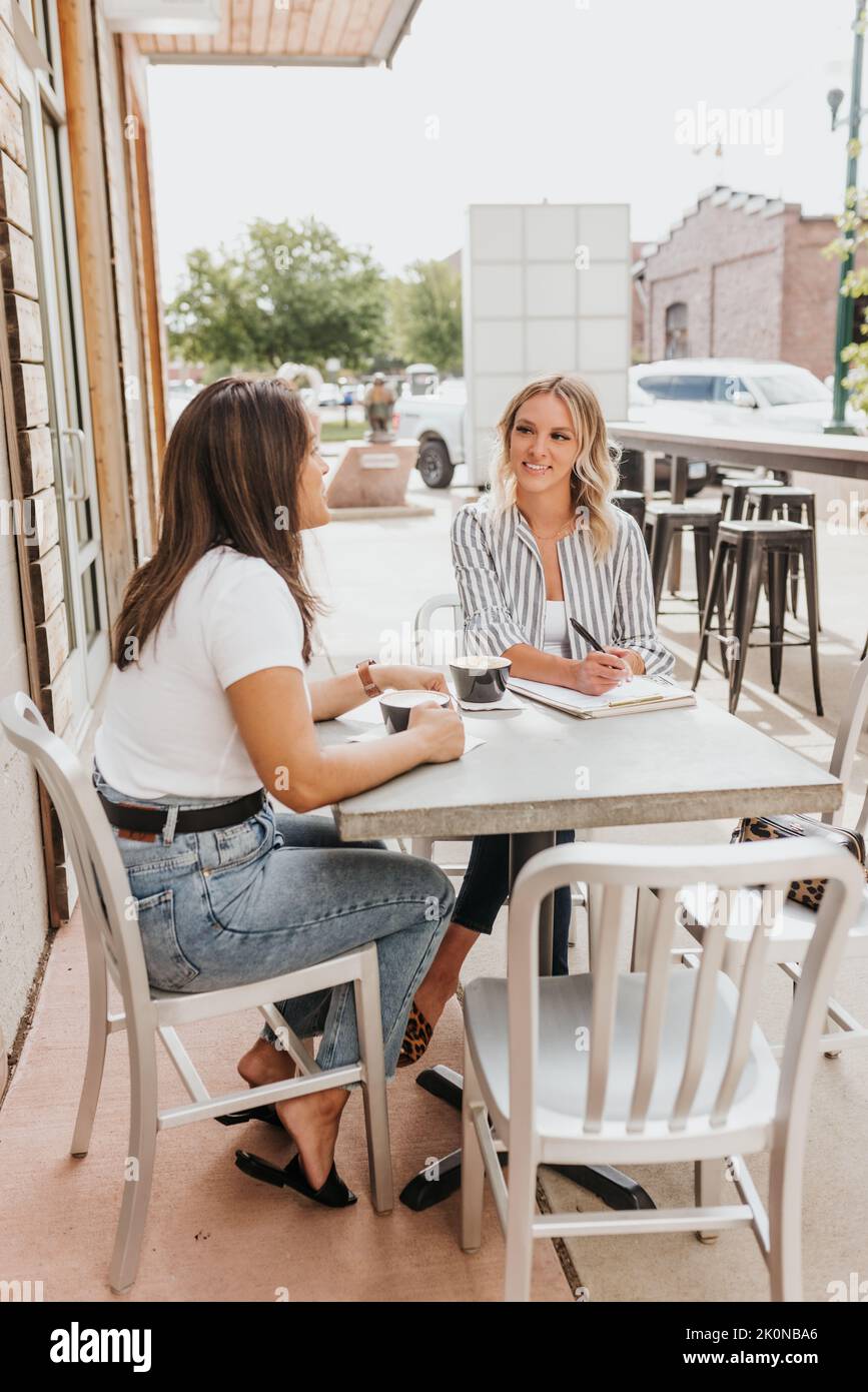 Two young professional females laugh together during meeting Stock Photo