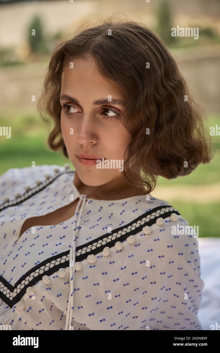 portrait of young curly caucasian pretty girl relaxing outdoors Stock Photo