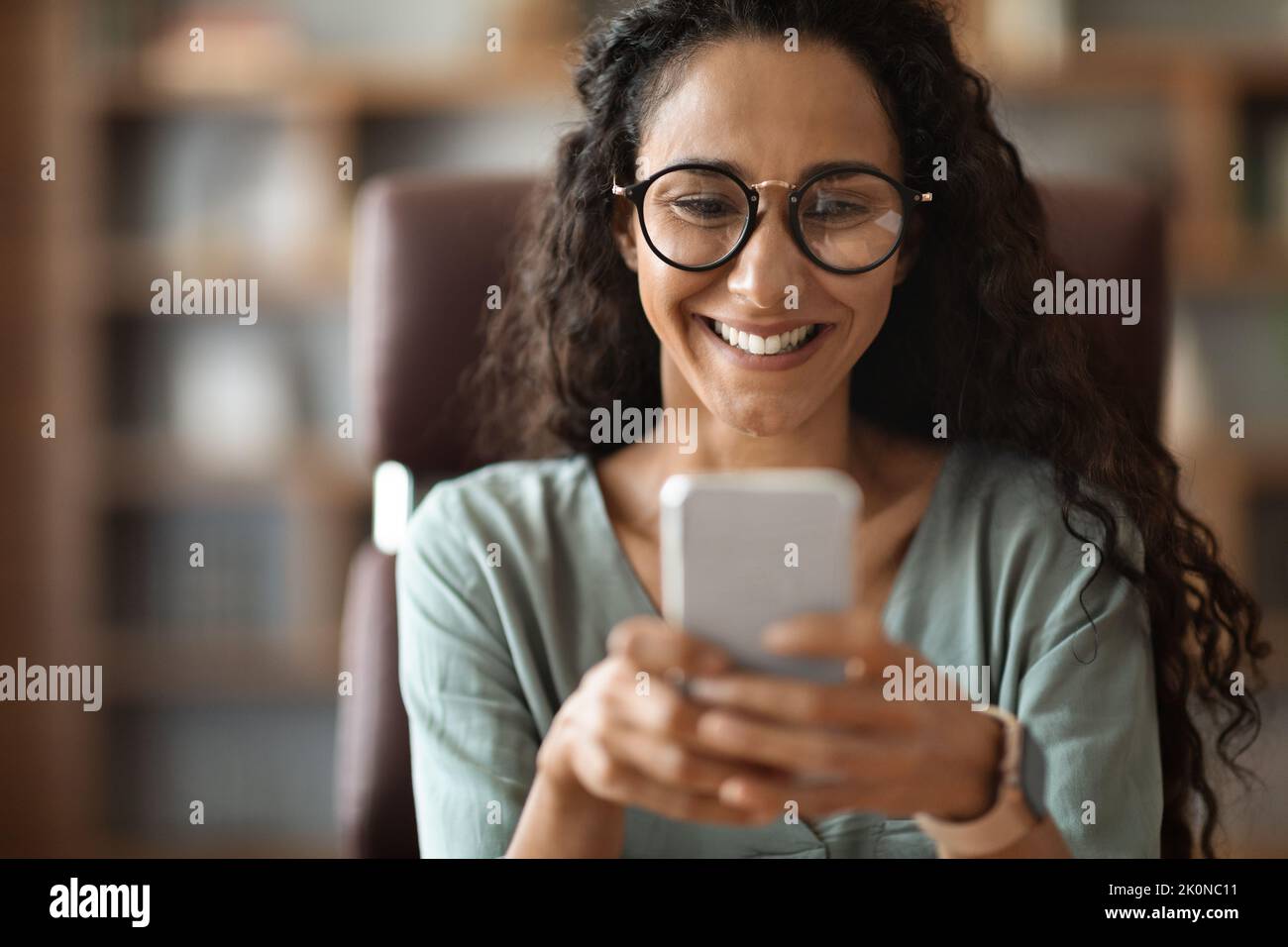 Closeup of happy brunette woman using smartphone Stock Photo