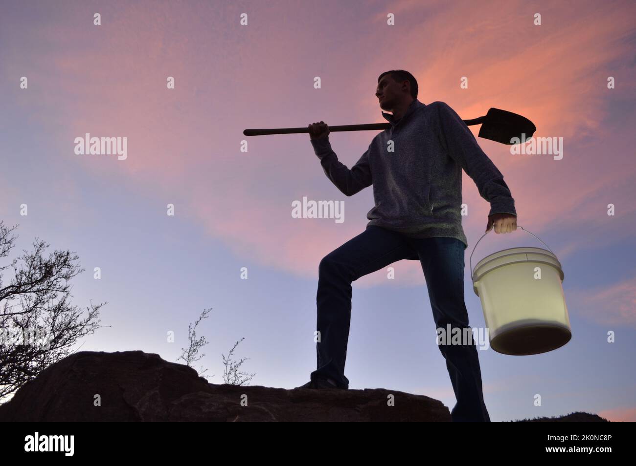 Man carrying shovel & bucket of light Stock Photo Alamy