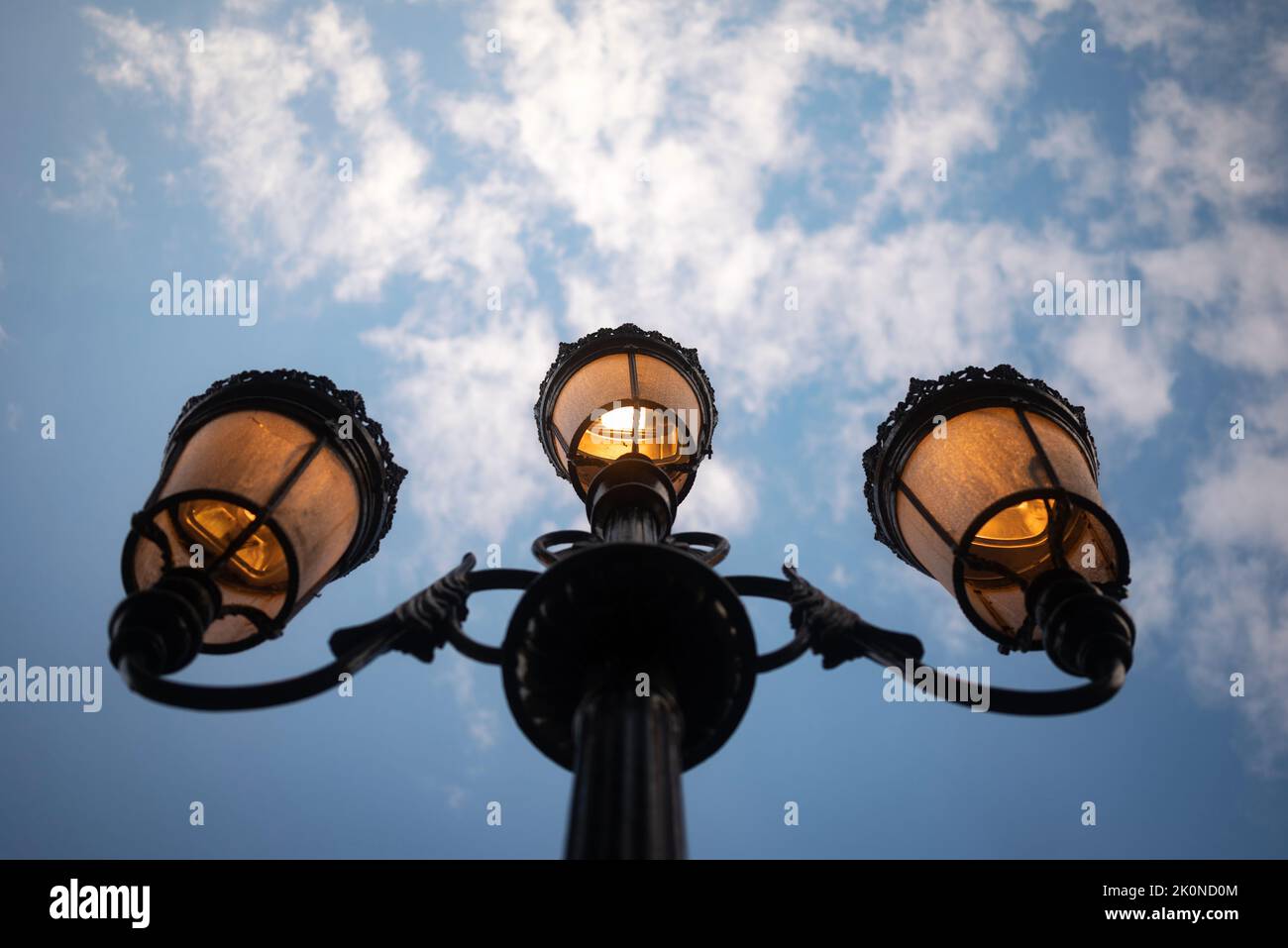 Lit street lantern in the daytime. Light from antique old-fashioned street lamp Stock Photo