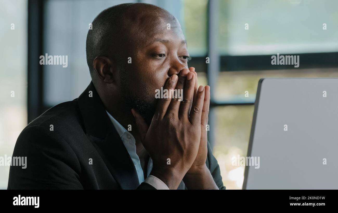 Tired stressful african male adult sad businessman feel tiredness discomfort eyestrain fatigue pain from hard overwhelmed computer work massaging dry Stock Photo