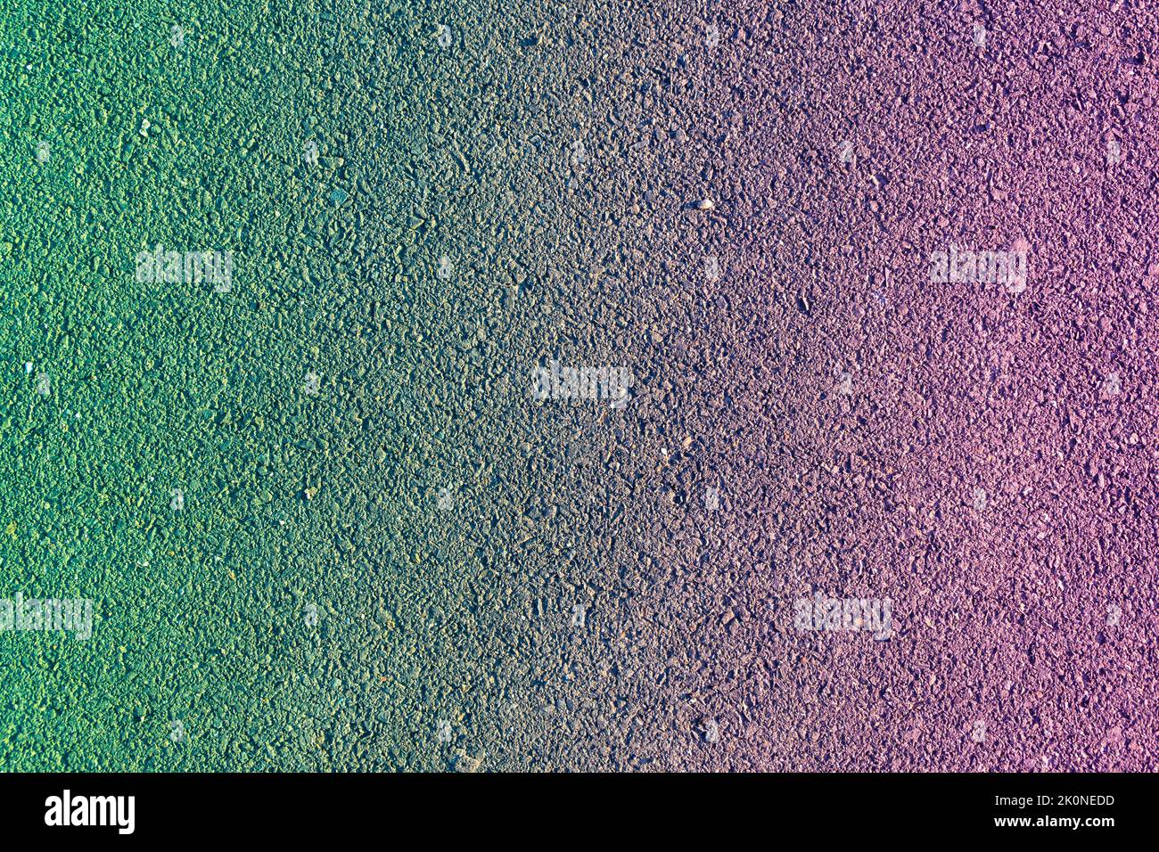 texture of a new asphalt pavement with small stone and sand with a red-green color gradient overlaid, selective focus Stock Photo