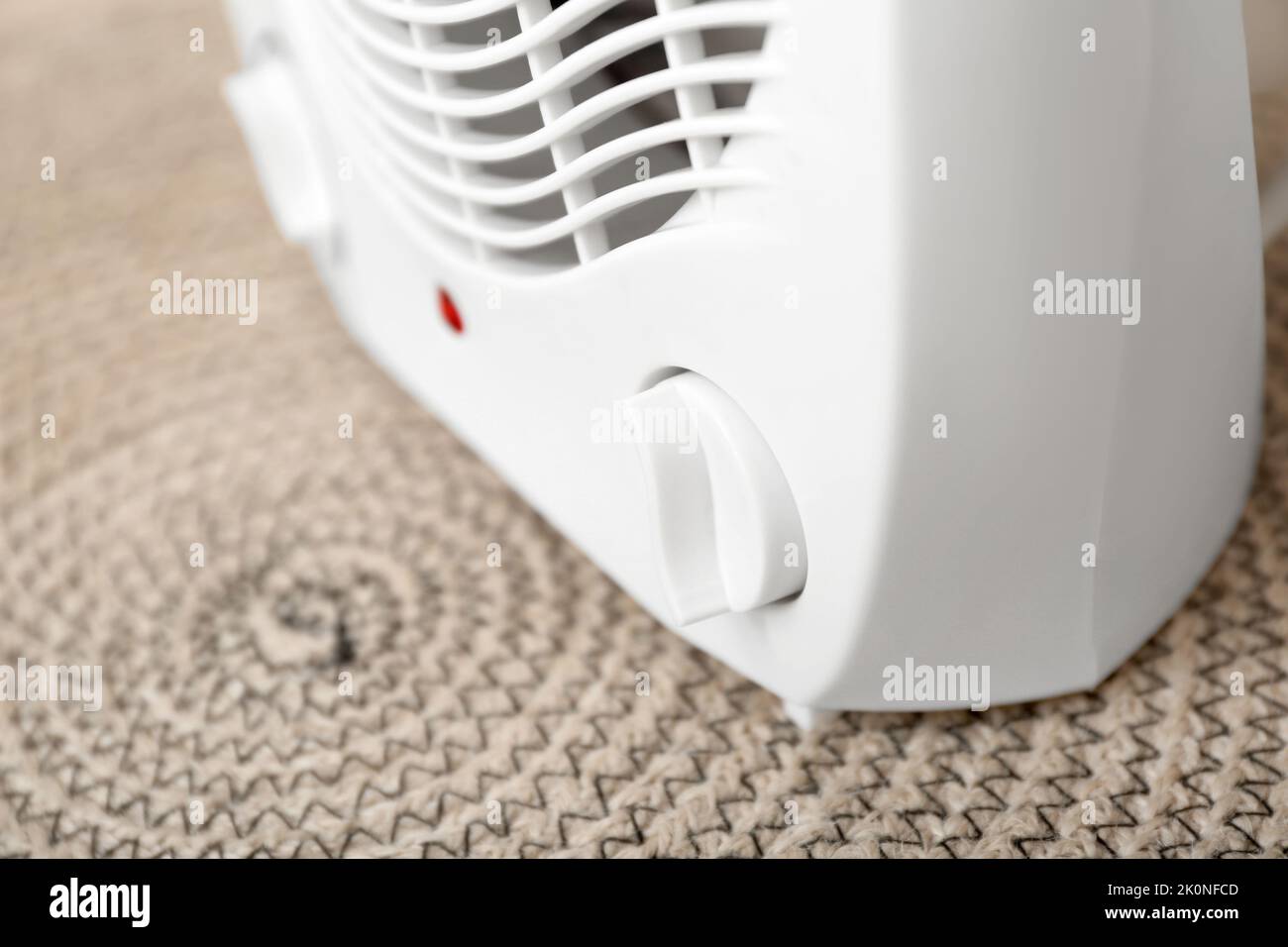 Electric fan heater on rug, closeup Stock Photo
