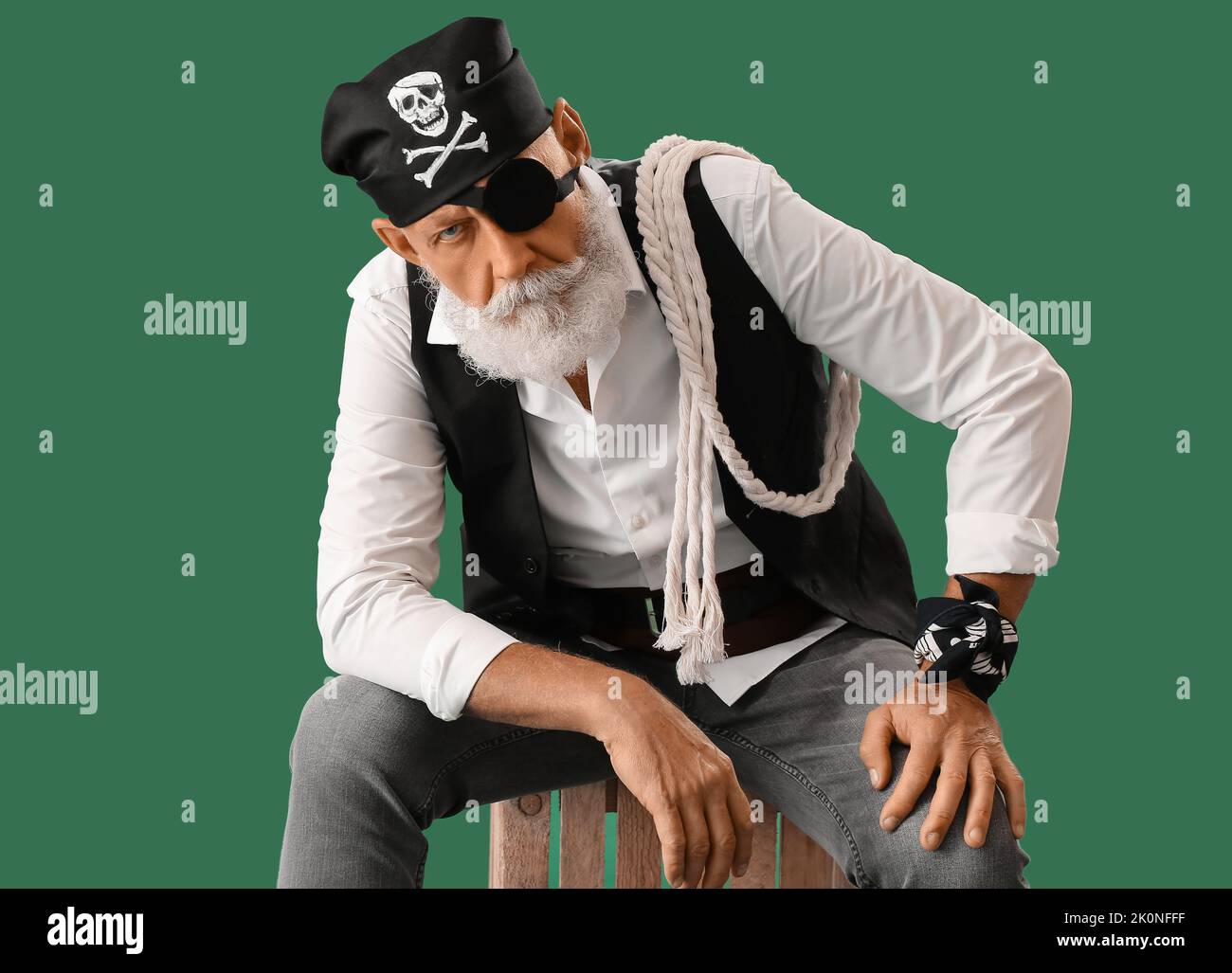 Old pirate with rope sitting on green background Stock Photo - Alamy