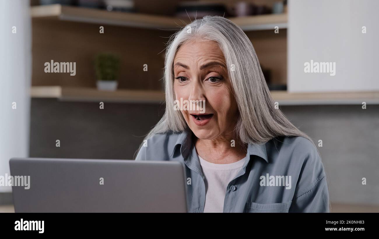 Caucasian mature middle-aged female pensioner woman chatting online distance communication remote with family children during quarantine looking at Stock Photo