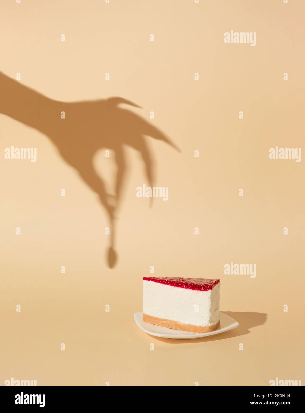 Halloween minimal concept with cheesecake and witch or zombie hand shadow. Creative spooky holiday fun background. Stock Photo