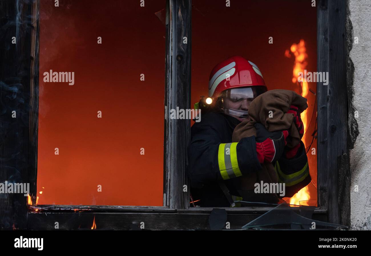 Firefighter hero carrying baby girl out from burning building area from ...