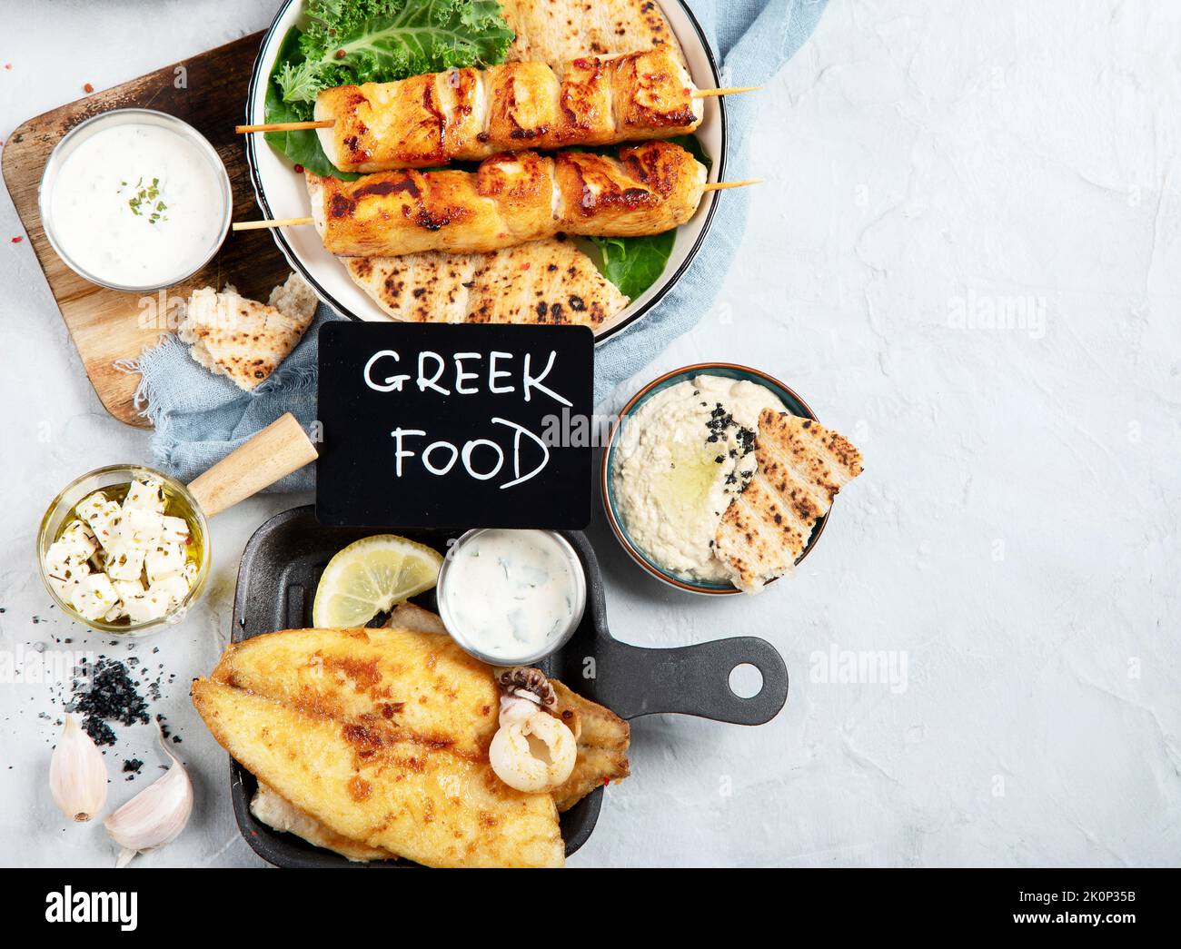 Greek food background. Meze, gyros, souvlaki, fish, pita, greek salad, tzatziki, assortment of feta, olives and meatballs. Traditional different greek Stock Photo