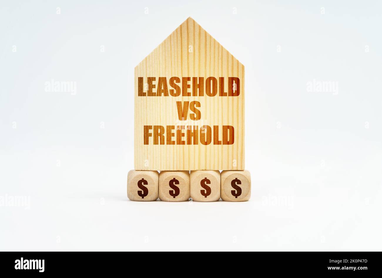Real estate and business. On a white surface stands a wooden model of a house with the