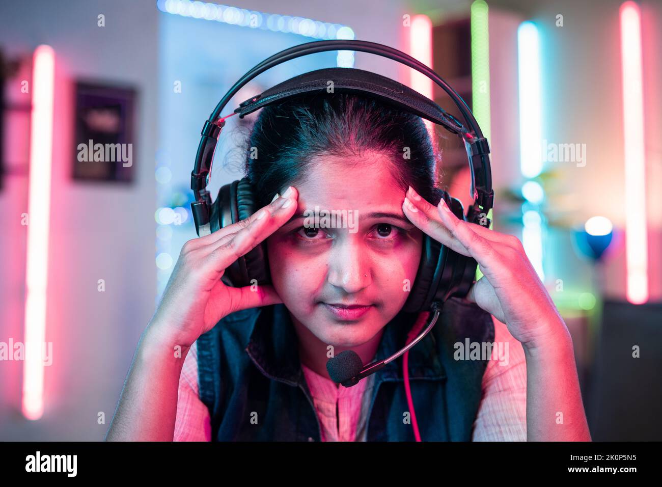 close up shot of worried gamer with headphone due to loss while playing online video game by looking camera at home - concept of live streamer Stock Photo