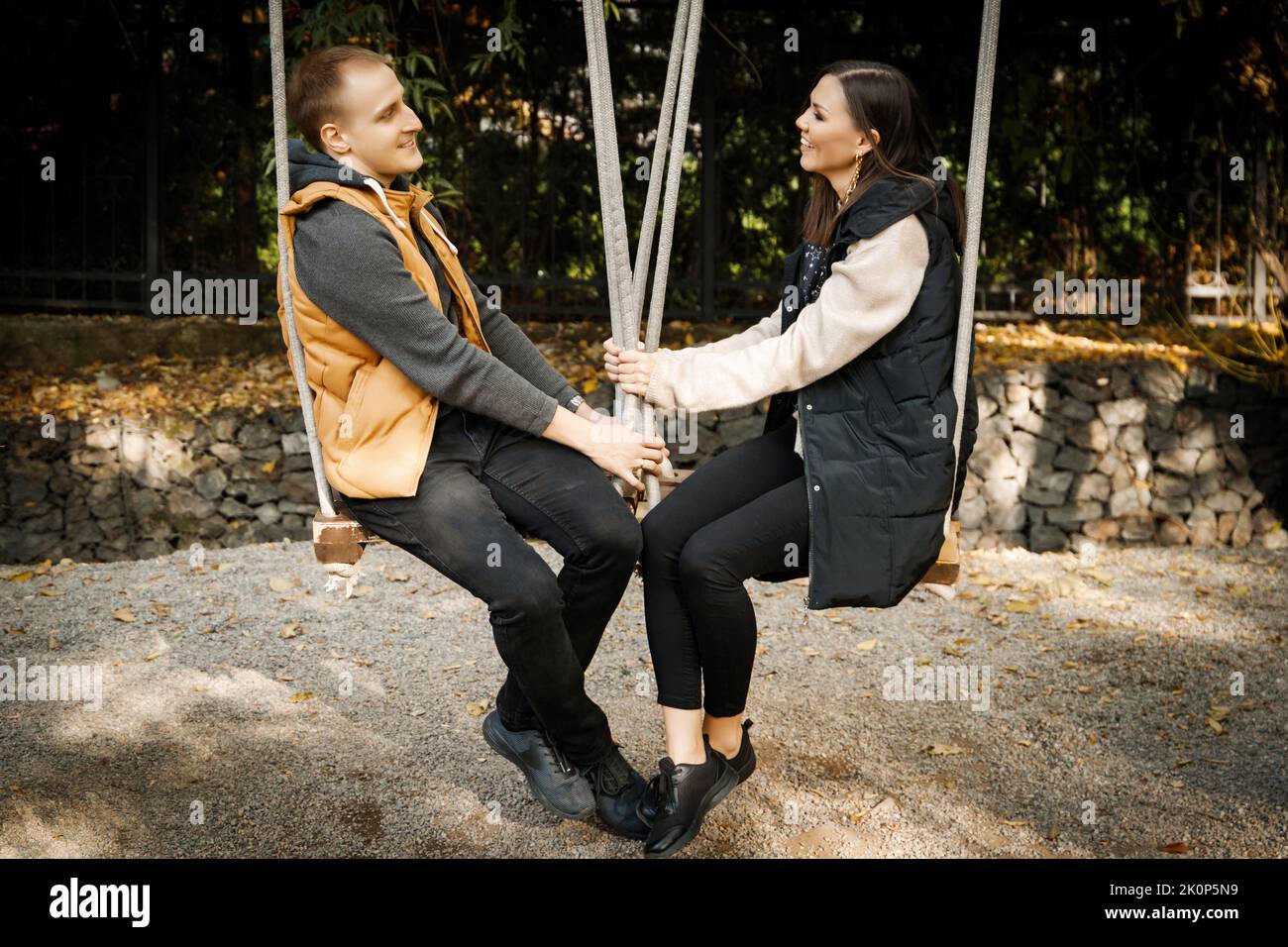 Young Interracial couple smiling happy on swing, Asian woman, Caucasian man outdoor Stock Photo