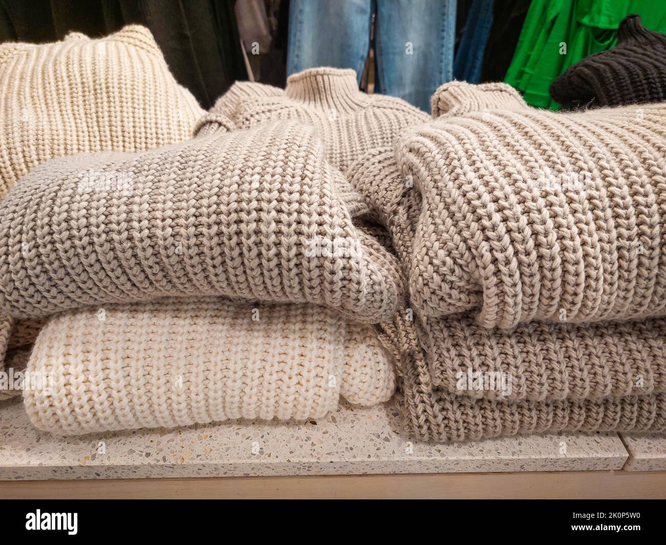 Stack folded sweaters in the clothing store. Knitted jumpers for cold fall and winter season. Autumn, winter clothes. Nobody, mobile photo Stock Photo