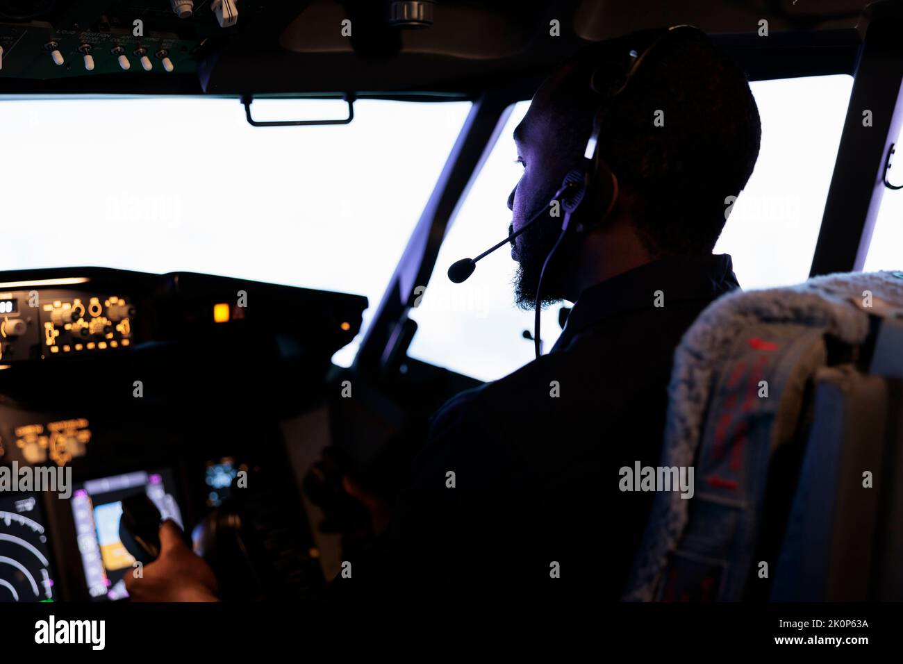 African american copilot holding lever to takeoff with airplane, flying aircraft with dashboard power buttons and control panel command. Radar navigation and windscreen compass. Close up. Stock Photo