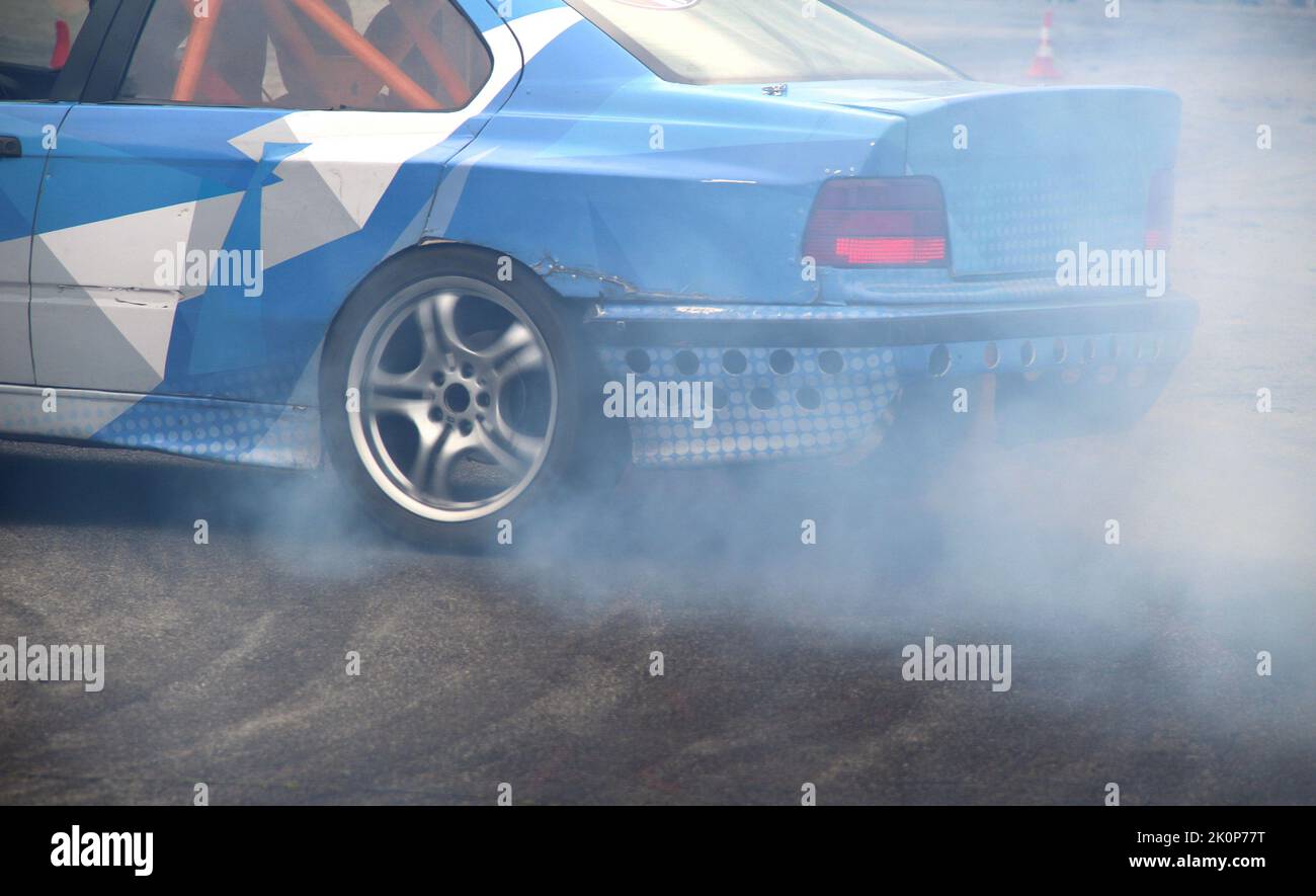 Rear wheel drive car drifting on the asphalt track with safety cones
