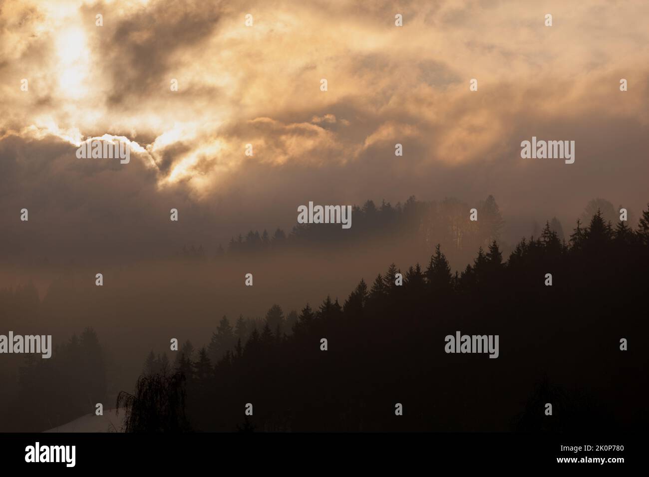 The brightness of the sun forms very different clouds and makes the mountain very mysterious and misty. Stock Photo