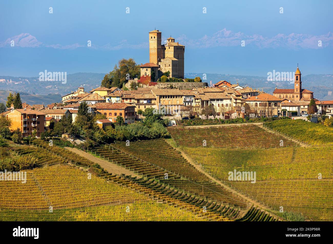 View of small town on the hill with colorful autumnal vineyards in Piedmont, Northern Italy. Stock Photo
