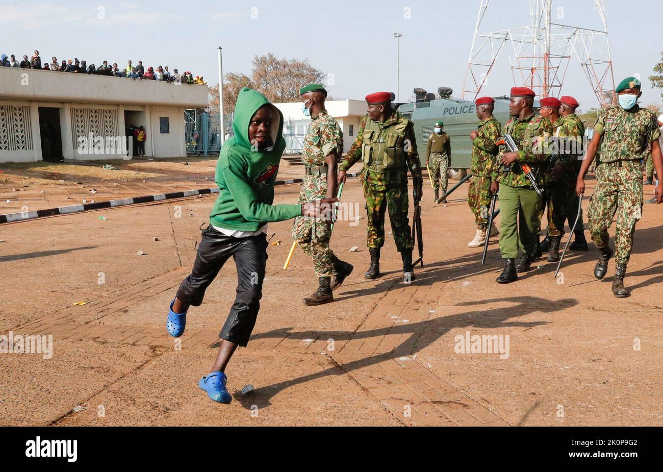 A boy runs past riot police as they attempt to control people jostling to attend the inauguration of Kenya's President William Ruto before his swearing-in ceremony at the Moi International Stadium Kasarani, in Nairobi, Kenya September 13, 2022. REUTERS/Thomas Mukoya Stock Photo