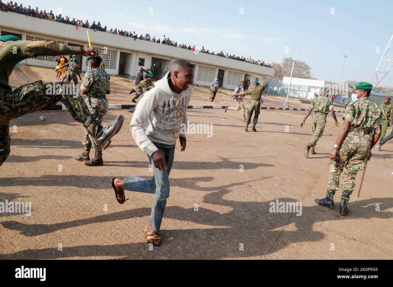 A man runs past riot police as they attempt to control people jostling to attend the inauguration of Kenya's President William Ruto before his swearing-in ceremony at the Moi International Stadium Kasarani, in Nairobi, Kenya September 13, 2022. REUTERS/Thomas Mukoya Stock Photo