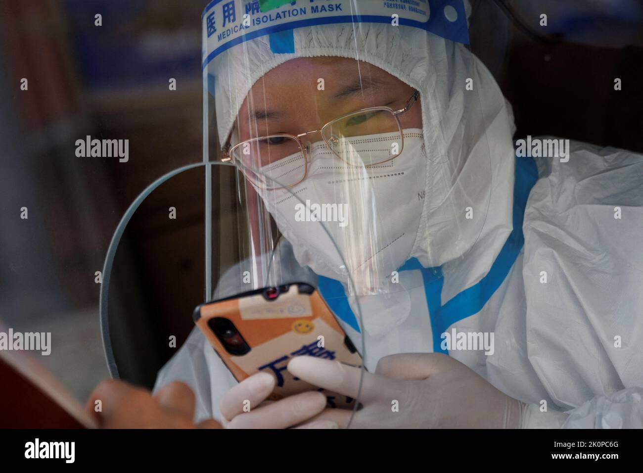 A pandemic prevention worker enters the personal information of a person in a nucleic acid testing booth following a coronavirus disease (COVID-19) outbreak in Beijing, China, September 13, 2022. REUTERS/Thomas Peter Stock Photo