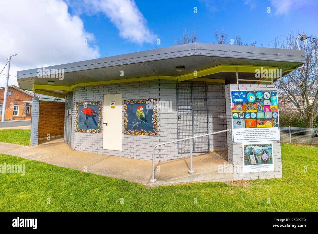 public toilets with Mural painted on wall alongside public notice