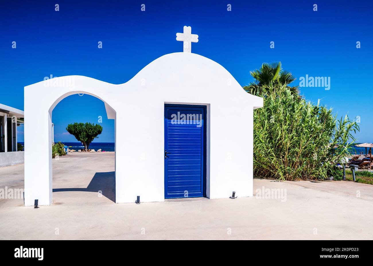 Traditional Greek white chapel on seaside of resort Faliraki in Rhodes island, Greece Stock Photo