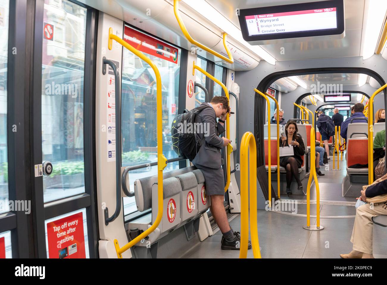 Sydney light rail train in Sydney, carriage interior with passengers travelling and schoolboy on his phone,Sydney city centre,NSW,Australia Stock Photo