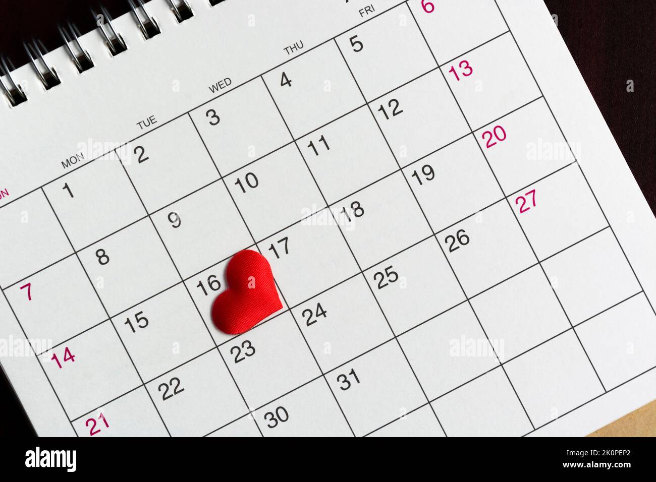 Red heart shape on the date of the 16th day in the calendar. Stock Photo
