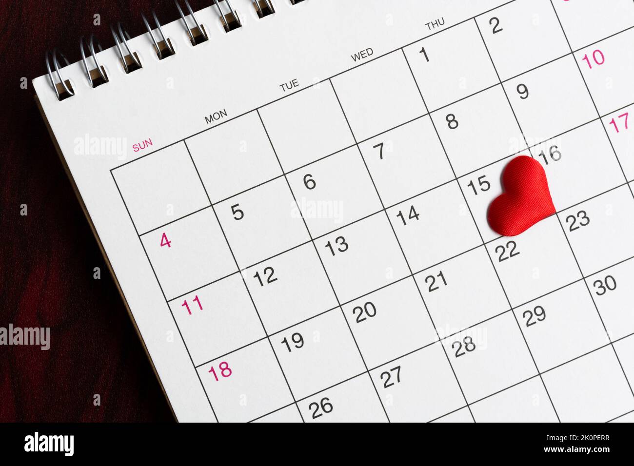 Red heart shape on the date of the 15th day in the calendar. Stock Photo