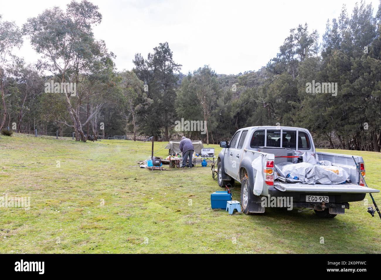 Man cooking at an Australian campsite in New South Wales,with Mazda ute
