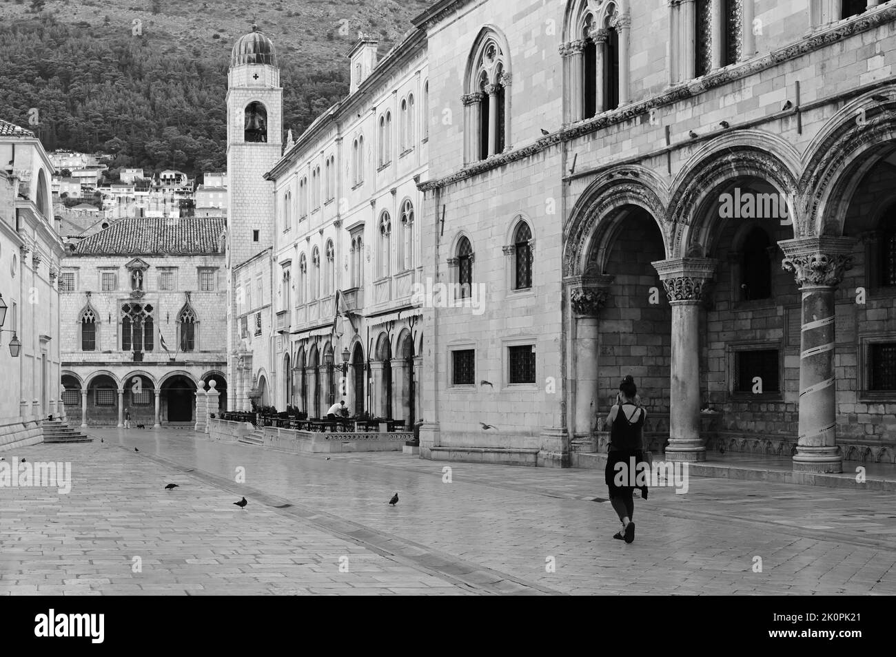 A lady tourist walking past The Rectors palace in Dubrovnik. Stock Photo