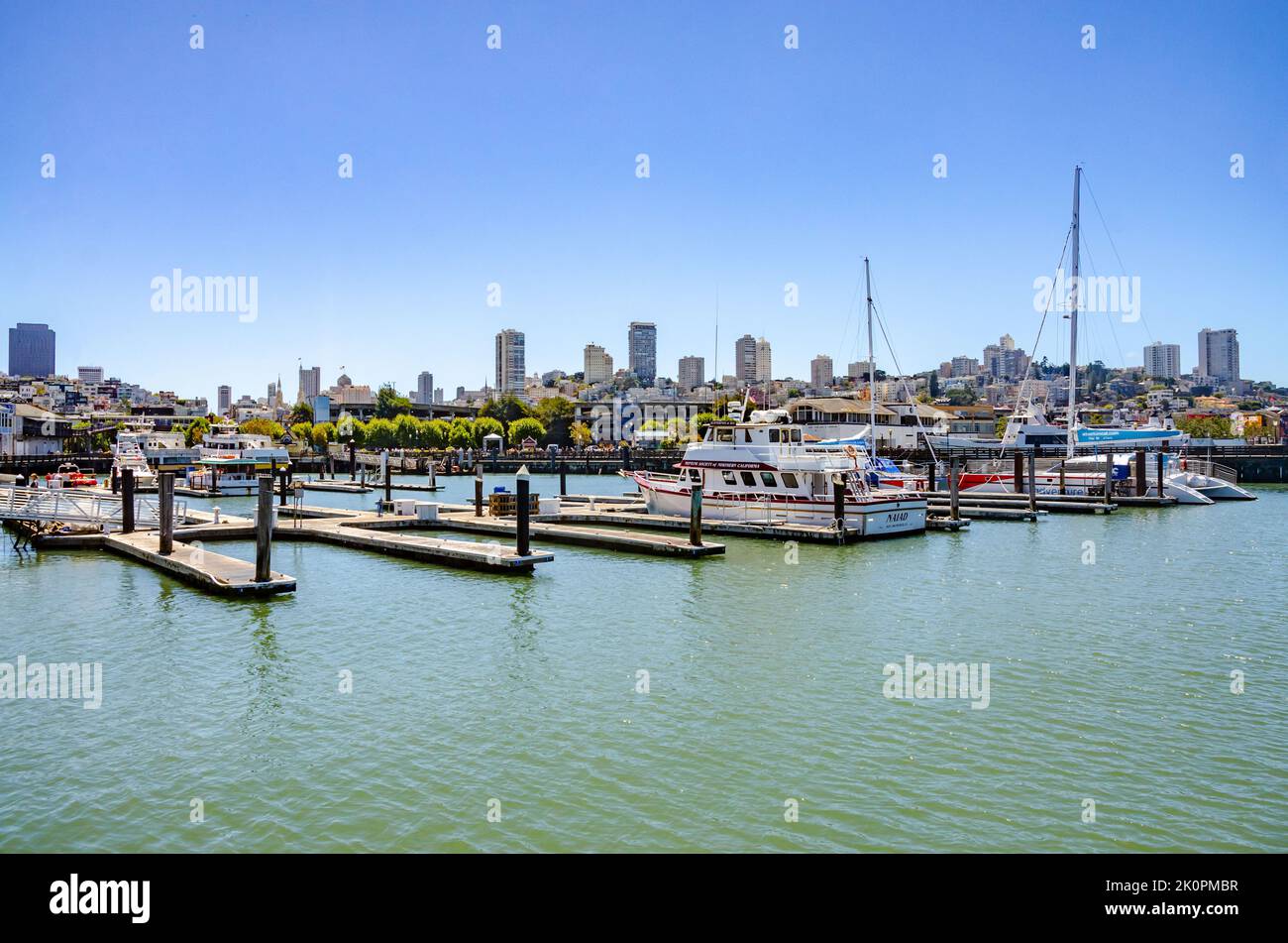 Boats moored at pontoons in the marina at Pier 39 in San Francisco, California with the San Francisco cityscape beyond. Stock Photo