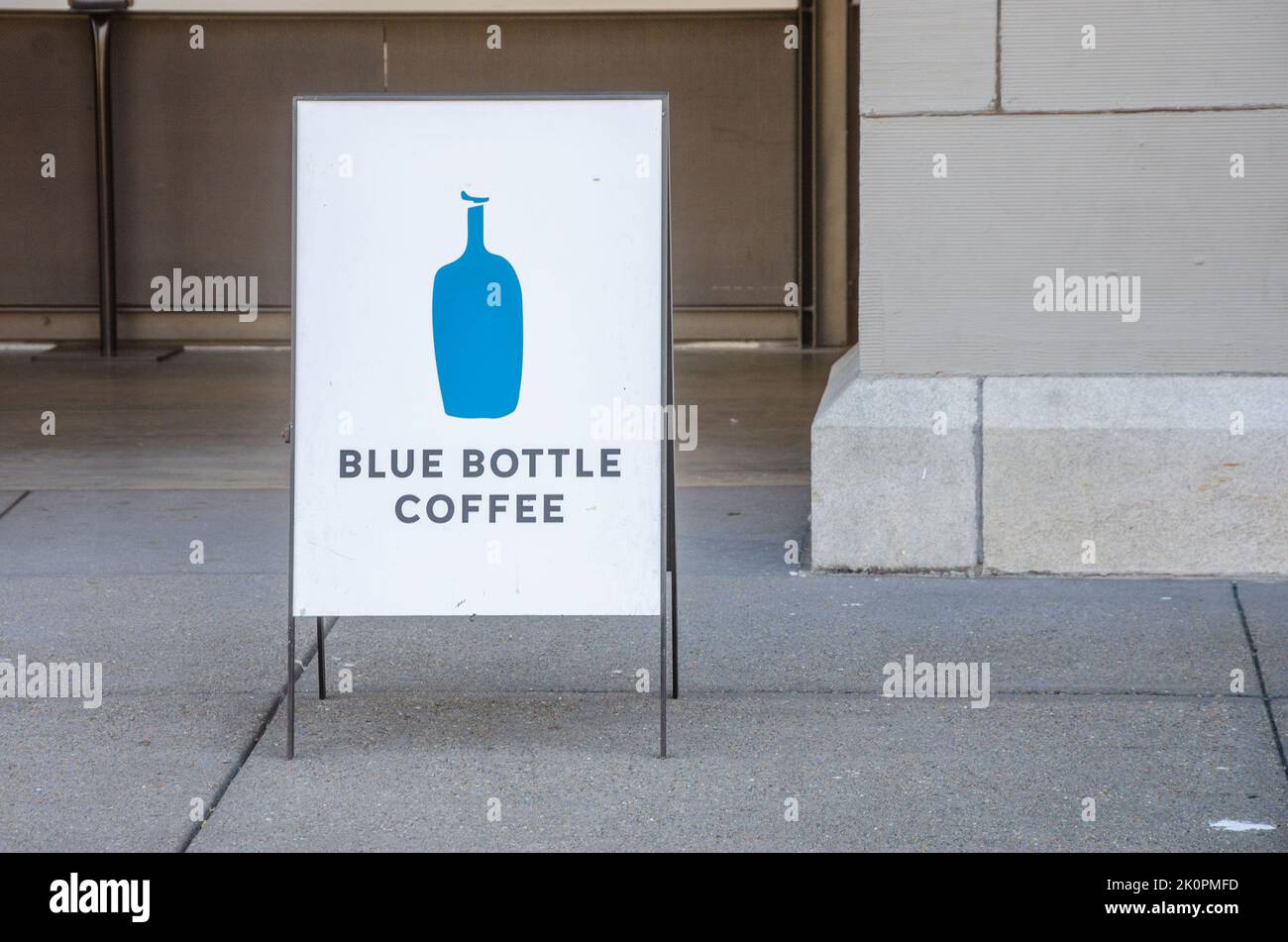 A sign for The Blue Bottle Coffee stands on the pavement alongside Embarcadero in San Francisco, California Stock Photo