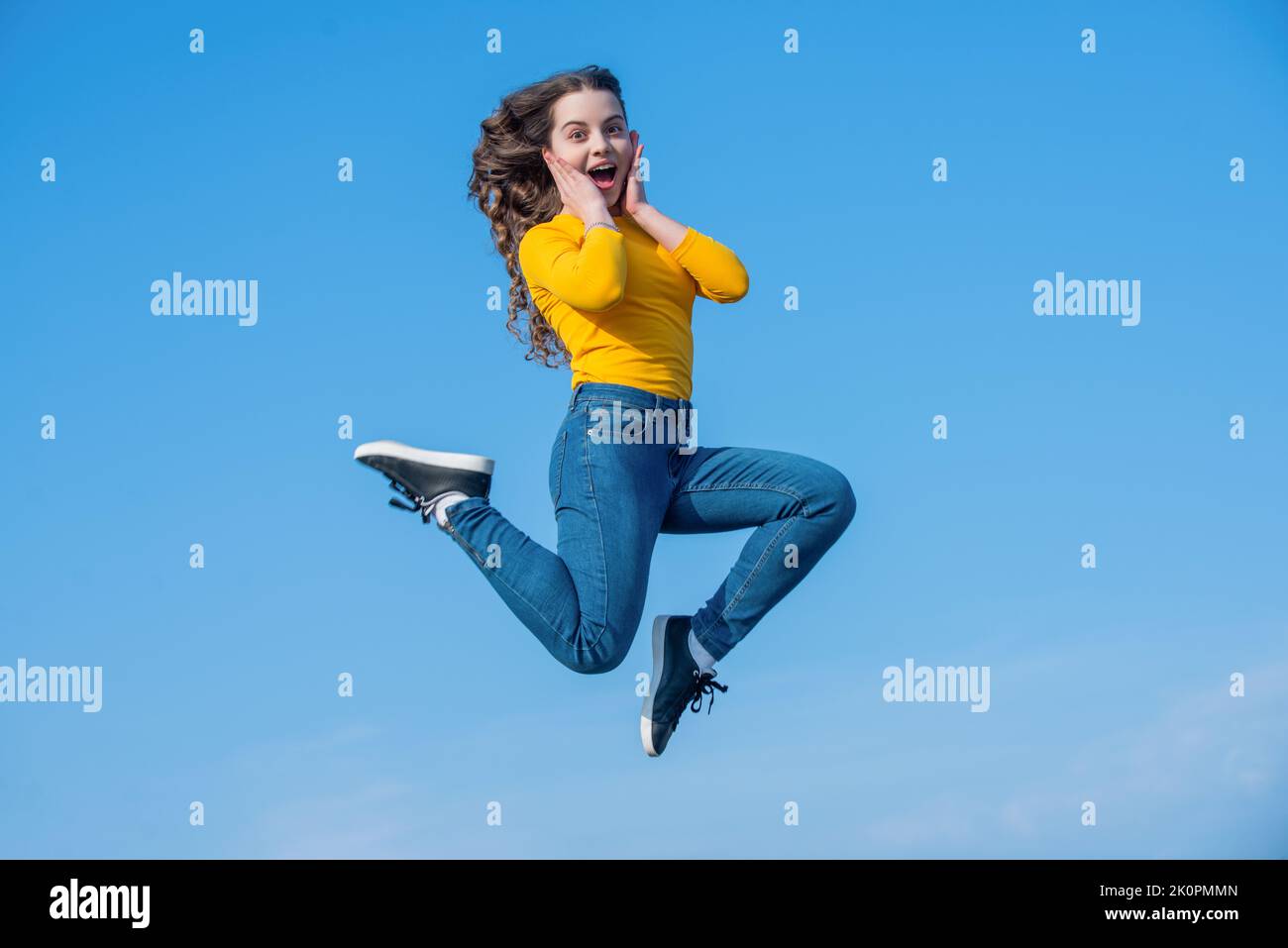 glad teen girl jump high on sky background Stock Photo - Alamy